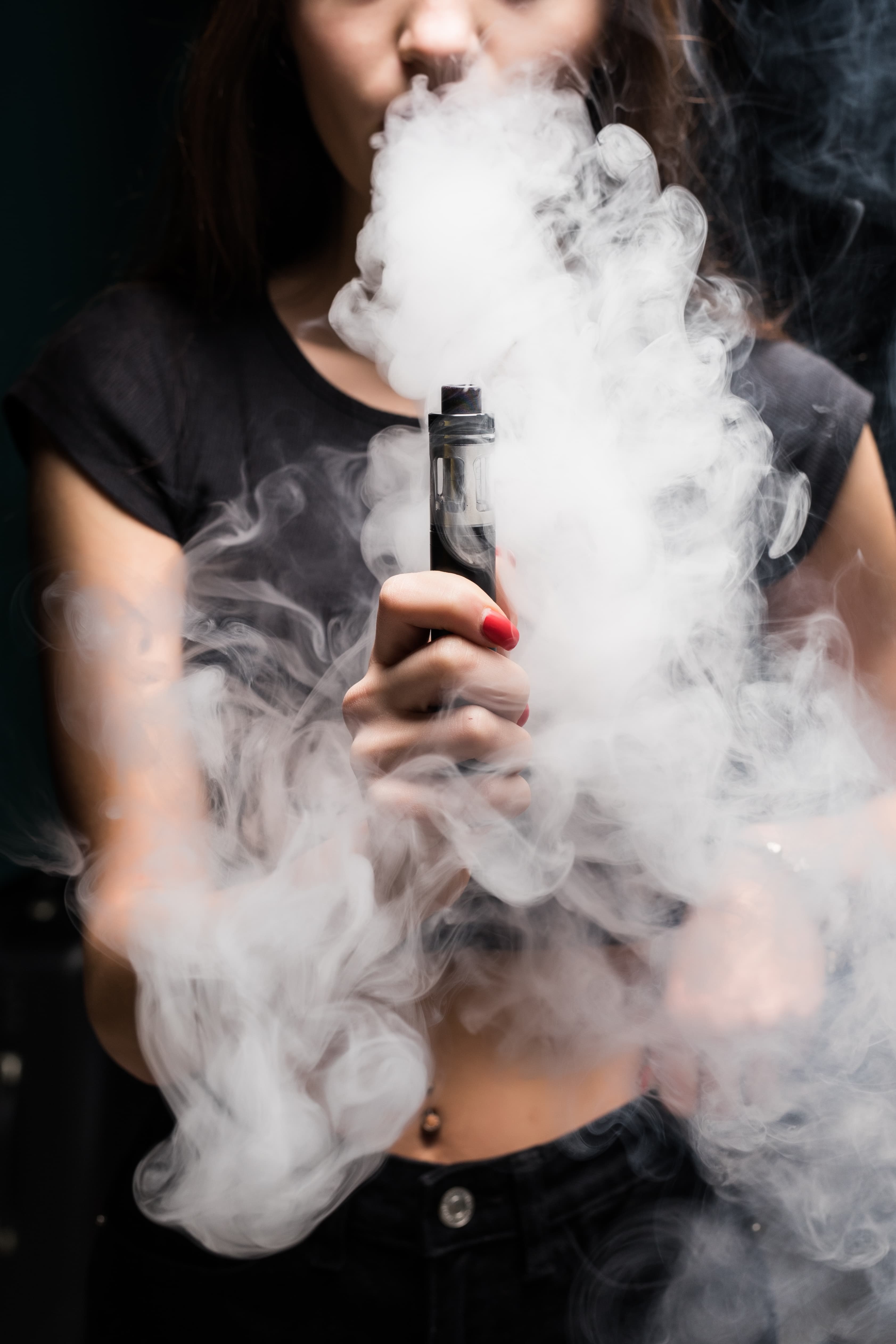 Person exhaling vapor from a handheld vape